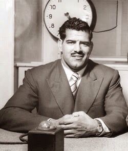 Dara Singh in a suit, seated at a desk