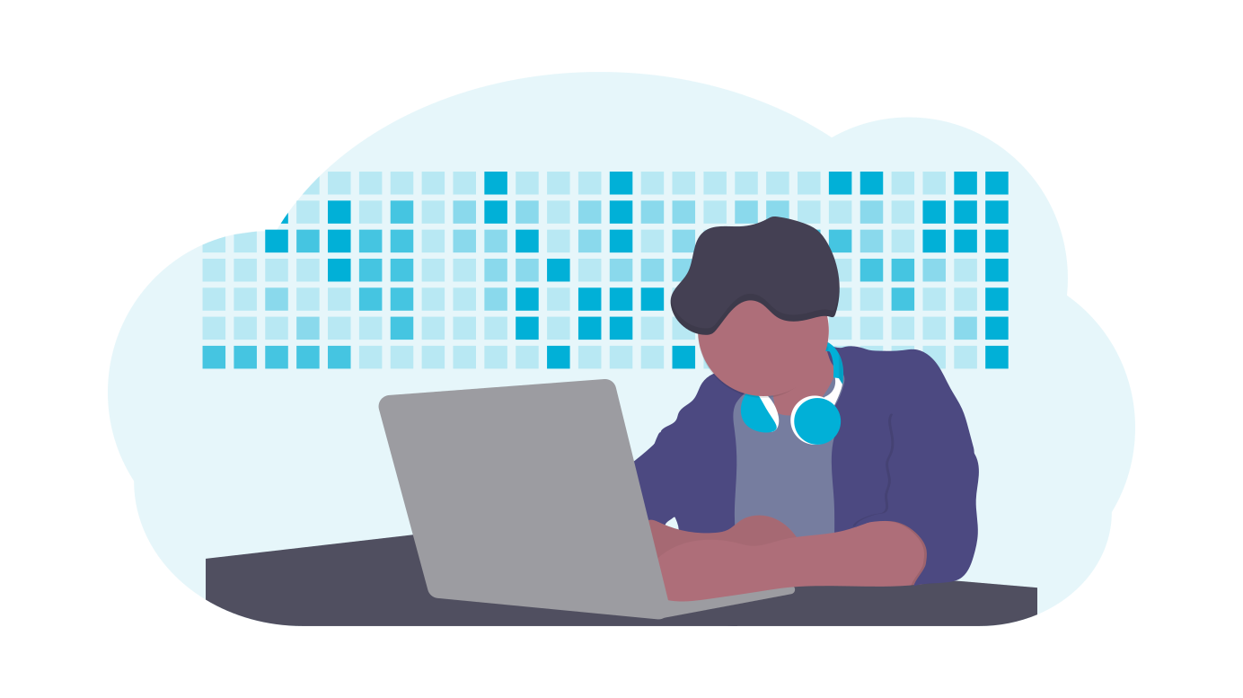 A person coding at a laptop in front of a wall of data tiles
